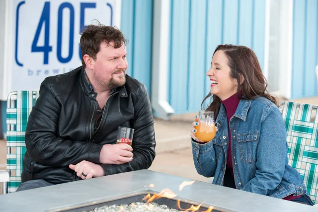 Lia and another model smiling at an outdoor table at 405 Brewing