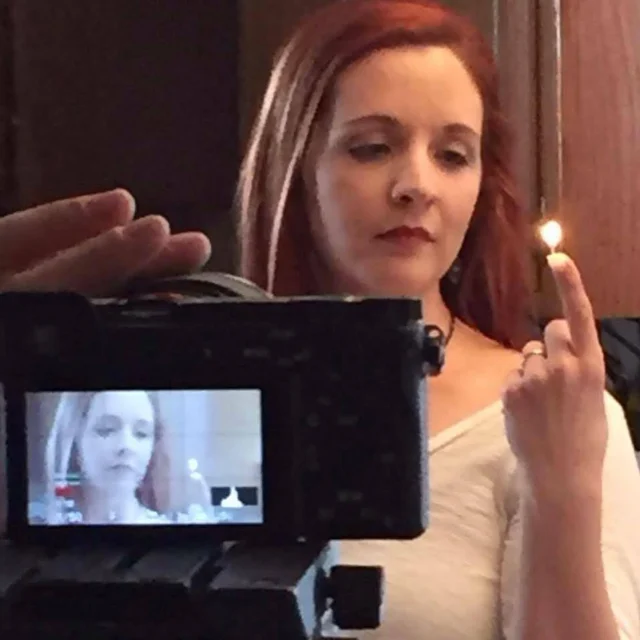 Lia in a candlelit portrait being filmed