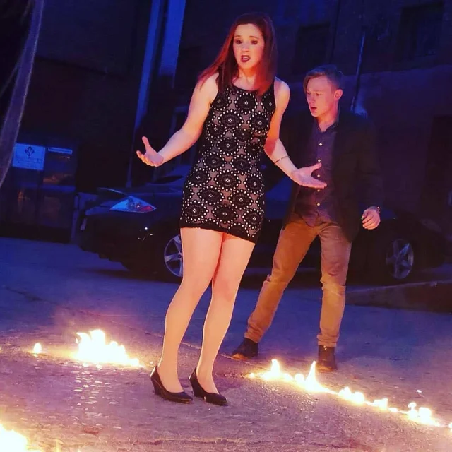 Lia performing on a stage with a line of fire