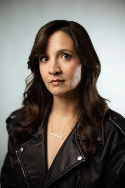 Lia in a black leather jacket against a soft gray background